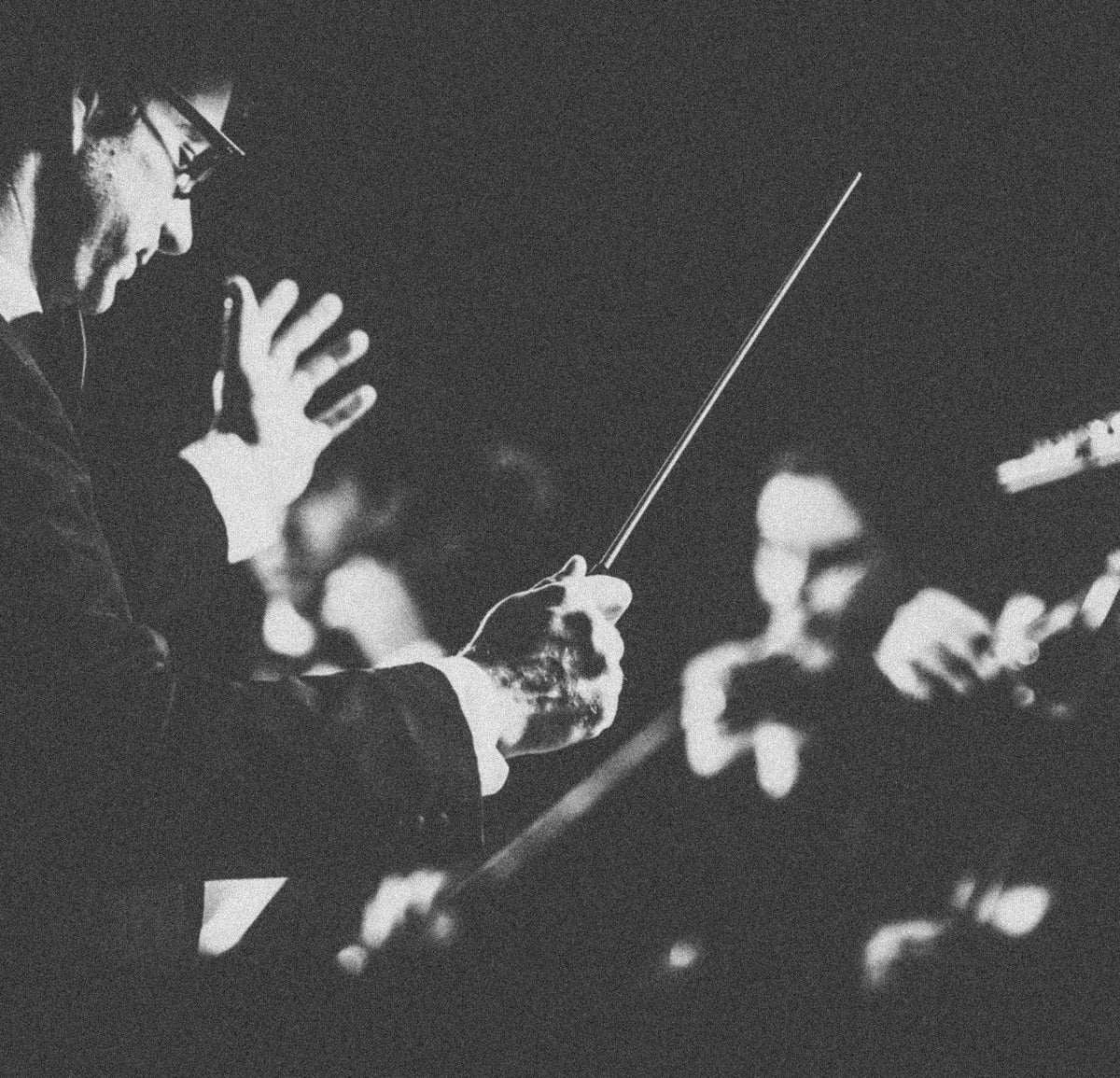A conductor leading an orchestra with a Rohema baton